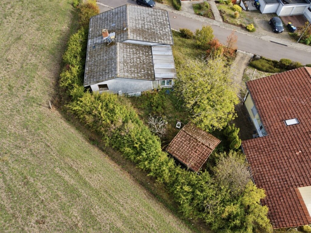 Luftaufnahme eines verwitterten Hauses im Grünen